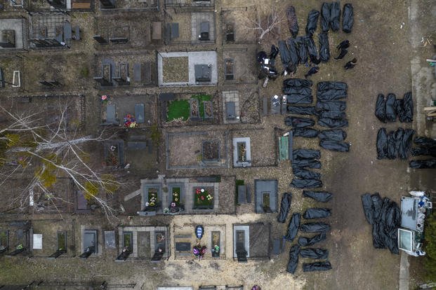 Policemen work to identify civilians killed during the Russian occupation in Bucha, Ukraine.