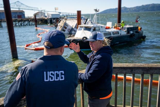 Coast Guard Sector Columbia River representative talks with federal official in Astoria, Oregon.