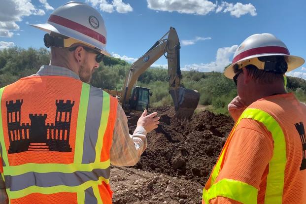 Two U.S. Army Corps of Engineers supervisors watch construction project in Arizona.