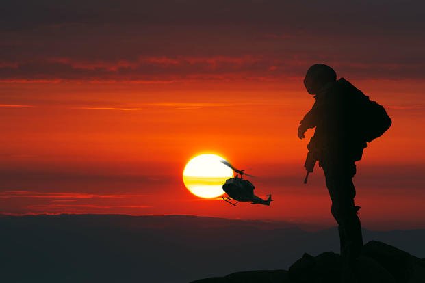 silhouette of soldier and helicopter with sunset