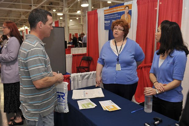 Indiana National Guard Sgt. Greg Lutz, an artilleryman with A Battery, 2nd Battalion, 150th Field Artillery in Greencastle, Ind., speaks with prospective employers at the seventh annual Operation Hire a Hoosier Vet Job Fair at the Indiana State Fairgrounds.