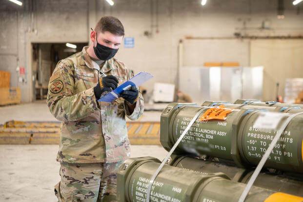 Staff Sgt. Kyle Davis, 436th Aerial Port Squadron special handling supervisor, counts pallets of ammunition, weapons and other equipment bound for Ukraine during a foreign military sales mission at Dover Air Force Base, Delaware.
