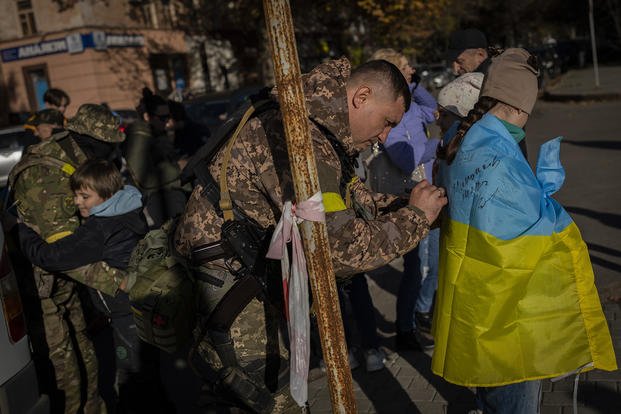 Ukrainian defence forces sign Ukrainian flags to residents in Kherson, southern Ukraine, Monday, Nov. 14, 2022. The retaking of Kherson was one of Ukraine's biggest successes in the nearly nine months since Moscow's invasion. 