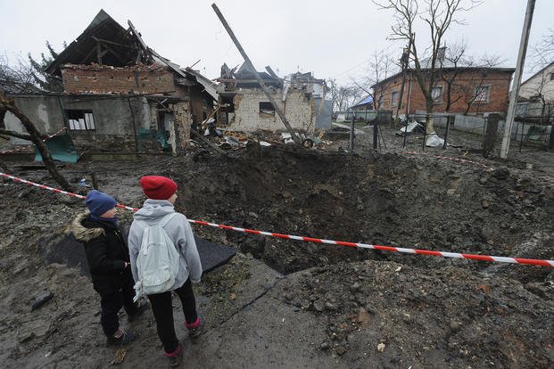 Children look at a crater created by an explosion in a residential area after Russian shelling in Solonka, Lviv region, Ukraine.