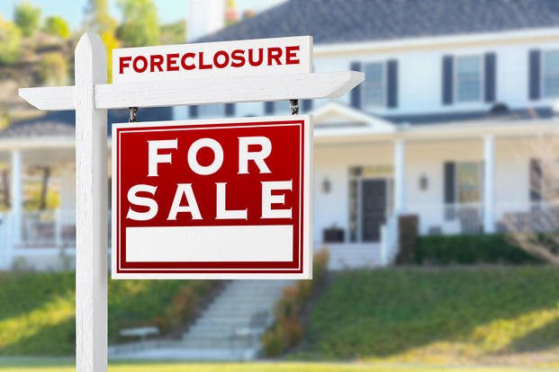 home with foreclosure sign in front