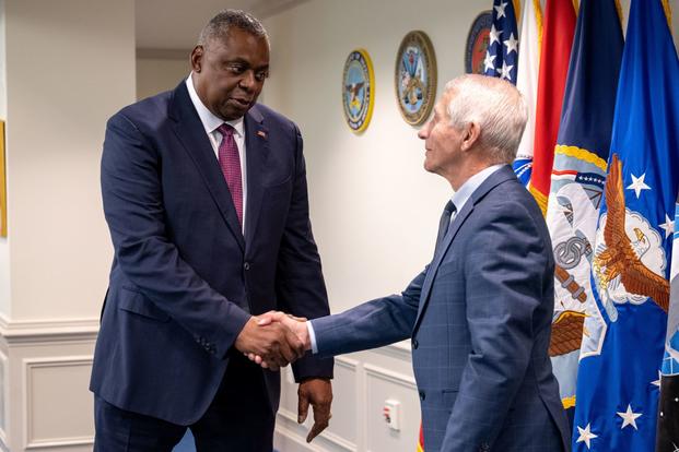 Secretary of Defense Lloyd J. Austin III shakes hands with Dr. Anthony Fauci at the Pentagon.