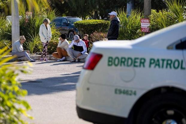 A group of people waits outside of the Customs and Border Protection office in Marathon, Florida. 