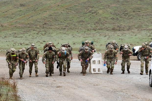 California Army National Guard soldiers walk while wearing military gear. 