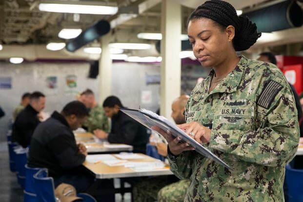 A sailor reads Navy-Wide Advancement Exam instructions.