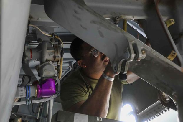 Mechanic removes the landing gear of an MV-22B Osprey.