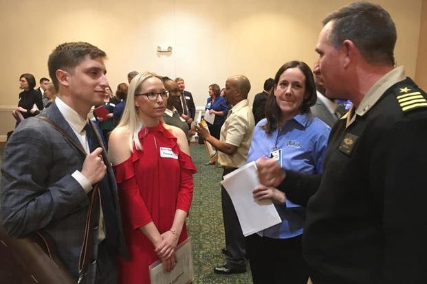 Capt. Casey Plew, Naval Surface Warfare Center Dahlgren Division (NSWCDD) commanding officer, and Susan Tubman, NSWCDD Staffing and Classification Branch head, discuss career opportunities with candidates at the fourth annual NSWCDD Career Fair in Fredericksburg, Va.