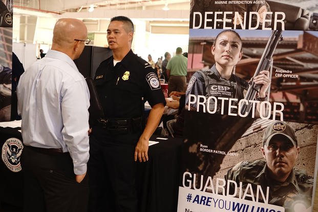 Henry Chong, a recruiter with U.S. Customs and Border Protection, speaks with military job seekers about career opportunities with his department at Wheeler Army Airfield, Hawaii.