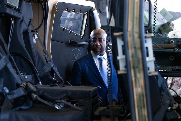U.S. Sen. Raphael Warnock (D-Ga.) looks at the inside of a joint light tactical vehicle after receiving a briefing on its capabilities at Fort Stewart, Georgia.