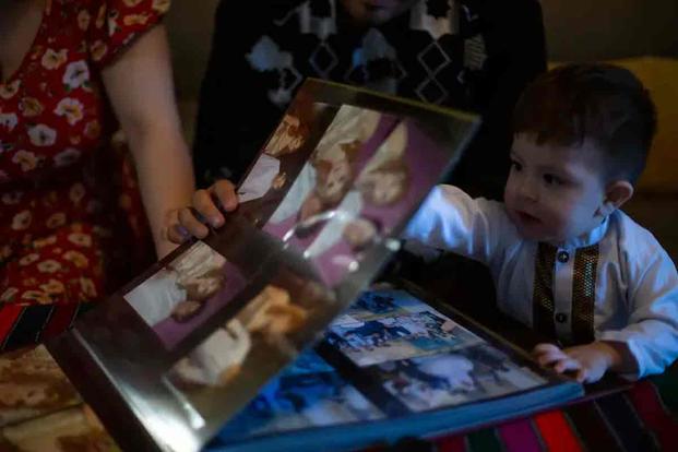 Refugees living in Austin look through wedding photos from Afghanistan.