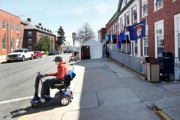Air Force veteran Willie Williams, 63, looks to cross the street outside the Soldiers' Home, on April 6, 2020, in Chelsea, Mass. The families of three residents of the veterans' care facility who died after contracting COVID-19 in the early days of the pandemic say in a federal lawsuit that the deaths were ‘premature and preventable’ and the result of ‘unsanitary, unfit, and unacceptable living conditions’ at the facility. 