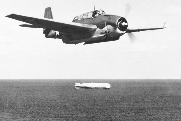 A U.S. Navy Avenger torpedo bomber swings low to send its cargo of destruction over Tonolei Harbor, Japanese base on Bougainville Island in the central Solomons.