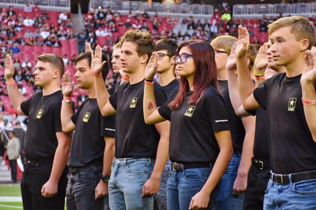 Future soldiers recite the oath of enlistment before an NFL game in Phoenix.
