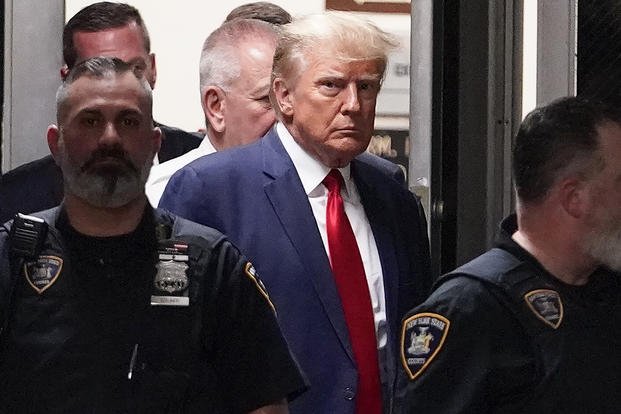 Former President Donald Trump is escorted to a courtroom