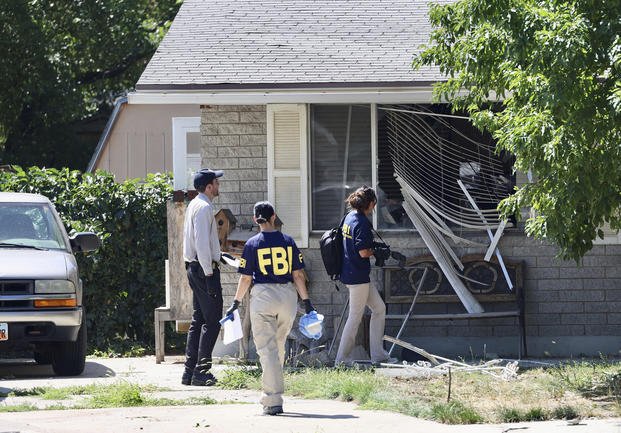 Law enforcement investigate the scene of a shooting involving the FBI
