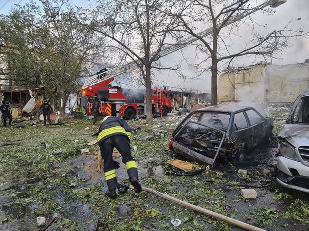 emergency services personnel work to extinguish a fire following a Russian attack in Cherkasy