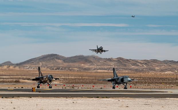 Two F-16 Falcons prepare to land as two F-1 Mirages wait to take off at Nellis Air Force Base
