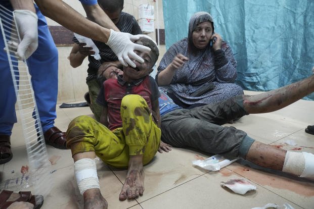 Palestinians wounded in an Israeli bombardment wait for treatment in a hospital in Deir al-Balah