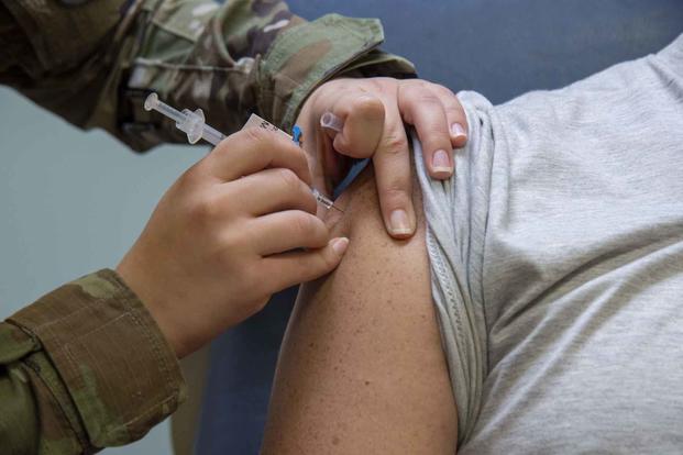 An airman provides a patient with the COVID-19 vaccine at MacDill