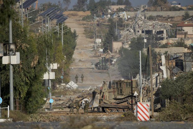 Israeli soldiers stand on Salah al-Din road in central Gaza Strip.