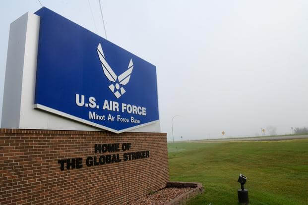 Heavy fog covers a sign at the front of the base entrance at Minot Air Force Base, North Dakota, Aug. 16, 2022.