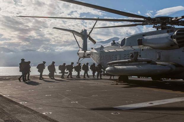 U.S. Marines board a CH-53E Super Stallion aboard the USS Bataan