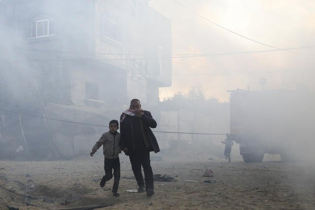 Palestinians run away after an Israeli strike on a residential building in Rafah