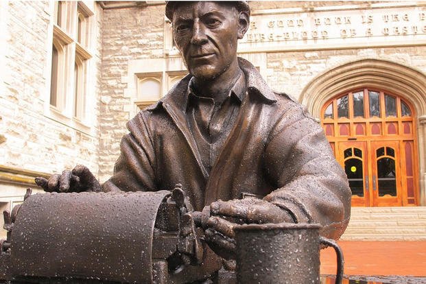 A statue of World War II correspondent Ernie Pyle typing on his typewriter sits in front of Franklin Hall at Indiana University.