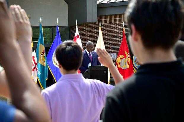 Secretary of Defense Lloyd J. Austin delivers the oath of enlistment to 85 new recruits