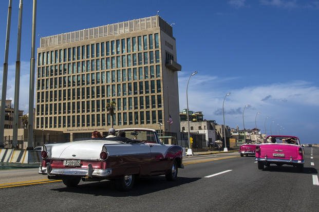 Tourists ride classic convertible cars on the Malecon beside the United States Embassy in Havana.