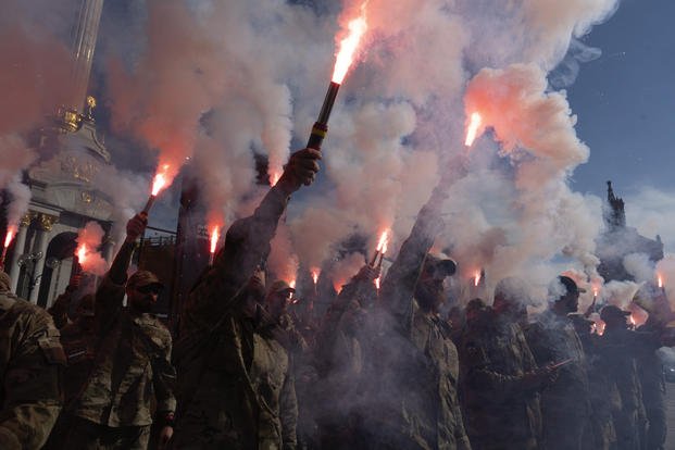 Soldiers of Ukraine's Azov battalion light flares at a rally