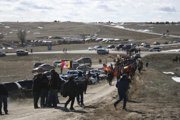 Members of the American Indian Movement walk to the Wounded Knee Massacre Monument in Wounded Knee, S.D. 