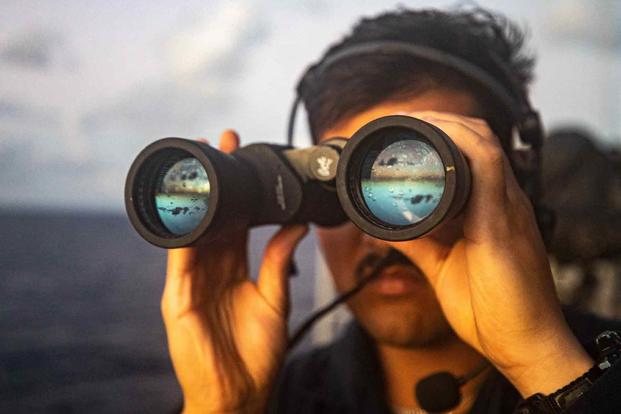 Navy sailor scans for surface contacts aboard the USS Chancellorsville