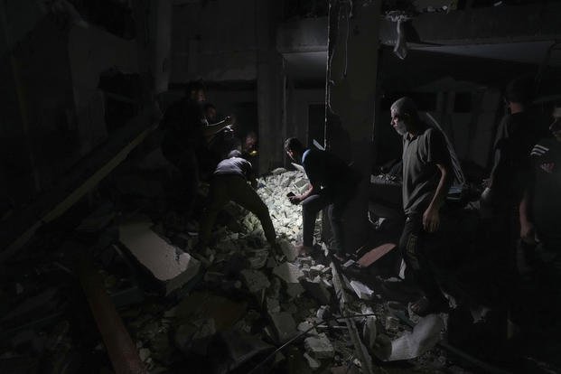 Palestinians search for survivors in the rubble of a mosque destroyed in an Israeli airstrike.