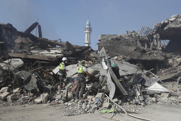 Hezbollah rescue workers search for victims on the rubble of destroyed buildings.