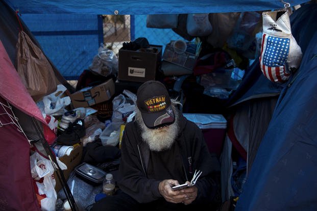 78-year-old Vietnam War veteran, who is homeless, looks at his smartphone