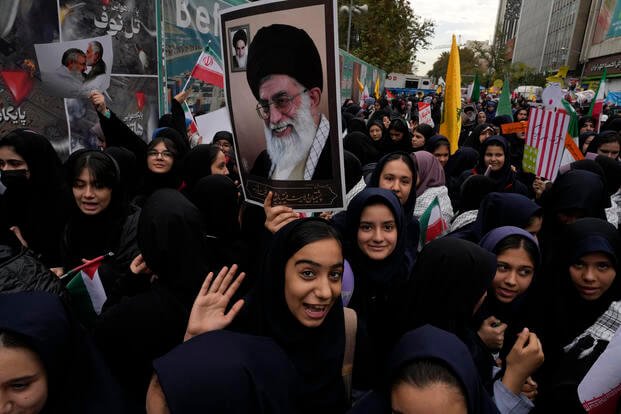 Students hold a poster of the Iranian Supreme Leader Ayatollah Ali Khamenei during a rally.