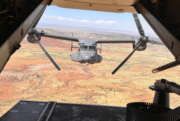 Two Air Force Special Operations Command CV-22B Ospreys fly low and fast in formation on a training range