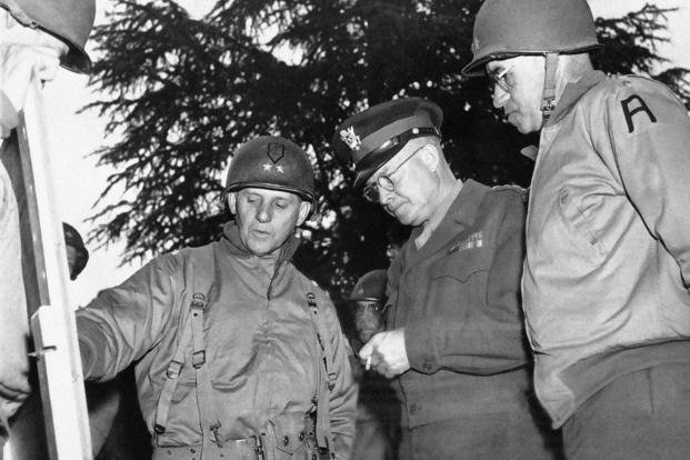 Gen. Dwight Eisenhower, center, talks with Maj. Gen. Clarence Hueber, left, commanding the U.S. First Division, and Lt. Gen. Omar Bradley at the latter’s headquarters in Normandy, France, during Operation Overlord on July 4, 1944. 