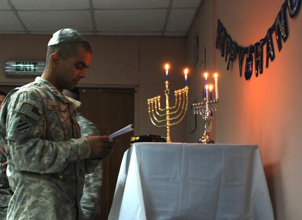 Spc. Daniel Oster, Company B, 2nd Battalion, 69th Armor Regiment, 3rd Brigade Combat Team, 3rd Infantry Division, meditates after lighting a menorah on Dec. 4, 2007, at the Camp Striker Chapel, Baghdad. 