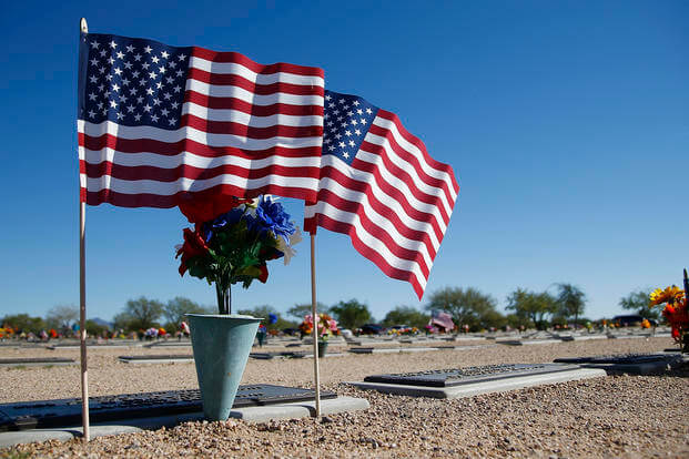 American flags fly at a gravesite at the National Memorial Cemetery of Arizona Monday, Nov. 12, 2018, in Phoenix.