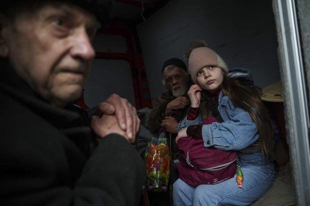 Hanna, 12, and her family sit inside a van during an evacuation from Pokrovsk, Ukraine
