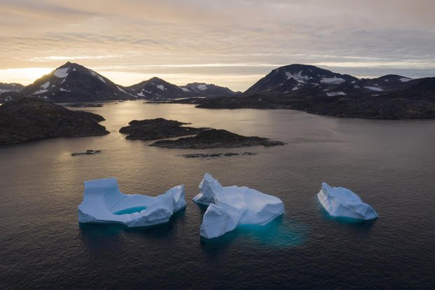 Large Icebergs float away as the sun rises near Kulusuk, Greenland