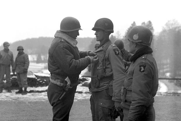 Then-Lt. Gen. George S. Patton pins an award on a 101st Airborne Division soldier in Bastogne as Brig. Gen. Anthony McAuliffe, the 101st commander in Bastogne, looks on. (Photo courtesy of the 101st Airborne Division)