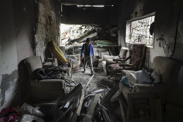 A child inspects the damage of his destroyed family home, in Bureij, central Gaza Strip