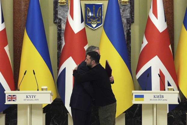 British Prime Minister Keir Starmer, left and Ukrainian President Volodymyr Zelenskyy hug